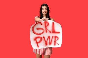 Young woman with sign GRL PWR on red background. Feminism concept