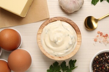 Tasty sauce with garlic and ingredients on white wooden table, flat lay