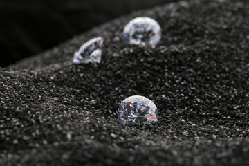 Beautiful shiny diamonds on decorative black sand