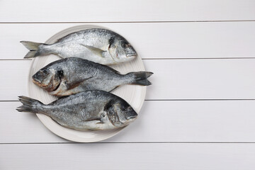Fresh raw dorado fish on white wooden table, top view. Space for text