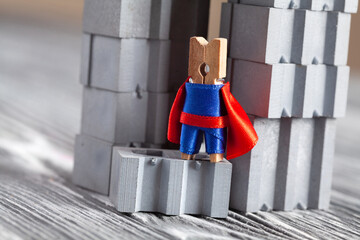 Wooden superhero clothespin and gray abstract building