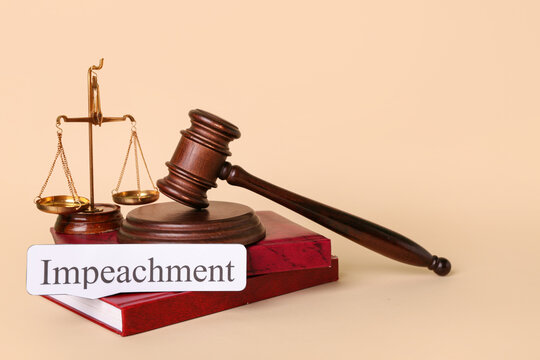 Word IMPEACHMENT, judge gavel, scales of justice and law books on beige background