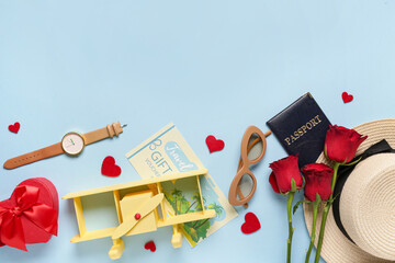 Travel accessories with toy airplane, hearts and roses on blue background. Valentine's Day celebration
