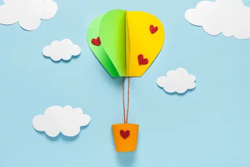 Fotobehang Paper hot air balloon with clouds on blue background. Valentine's Day celebration © Pixel-Shot