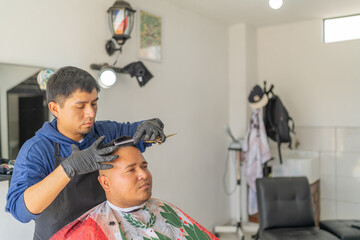 Customer sitting on a barber shop cutting his hair