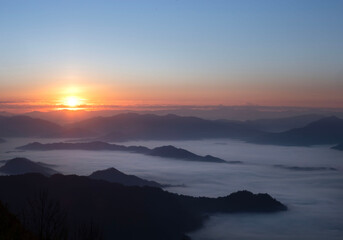 Scenic view of sea of clouds around mountain peaks at sunrise at Phu Chi Fa in Chiang Rai,Thailand.