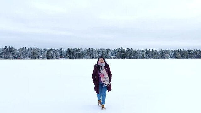 A woman enjoying and taking pictures of snow landscape. Cheerful girl enjoying beautiful winter day. Carefree lady having joyful emotions outdoor. Winter concept. Slow motion
