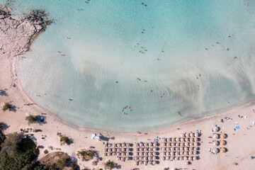 Elafonisi beach with pink sand, umbrella, Crete Greece. Aerial drone view of famous summer resort.
