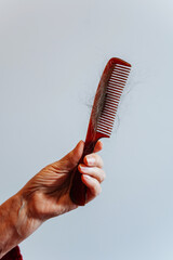 a woman's hair fell out due to cancer. the hair on the comb is due to chemotherapy. scraps of hair due to cancer on combing brushes