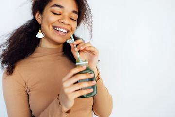 Young fitness afro woman holding a vegetables drink
