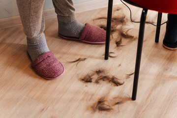 shaving a woman because of a cancerous tumor. shaved hair on the floor of a cancer patient. the...