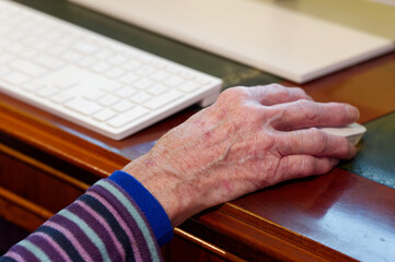 Senior elderly lady's hand on computer mouse