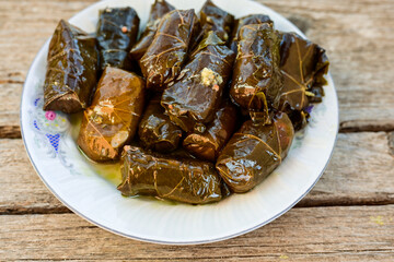 Dolmades - stuffed grape leaves  rolls  with rice the Greek way on wooden table .Stuffed greek wine leaves
