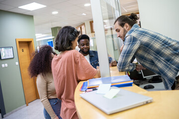 Obraz premium A group of students gathers around in the college lobby, each one diligently waiting on their college applications. 