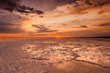 Fototapeta premium Sunset or sunrise sky. Clouds over water. Golden Dawn. Dramatic coast nature background. Beautiful sea beach at sunset. Morning shoreline sunlight. 