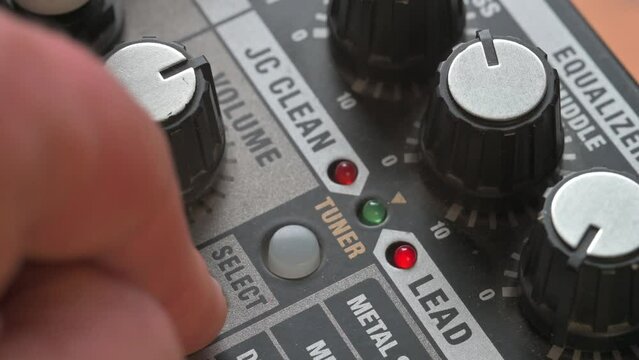 Man adjusting volume knob on guitar amplifier. 4k video footage UHD 3840x2160