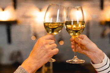 Close up photo of clinking glasses with wine on a romantic date