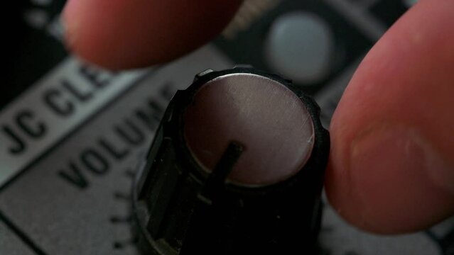 Man adjusting volume knob on guitar amplifier. 4k video footage UHD 3840x2160
