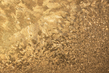Pattern of ice gold frost on the glass of window. Winter background ant texture. Close up