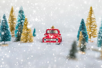 Creative Christmas decoration with red truck and colorful snowy spruces in the snow. Winter forest. Aerial, top view. Flat lay