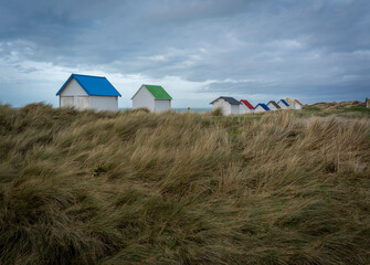 Gouville, France - 12 30 2023: View of colorful bathing wooden cabins of Gouville on the dunes.