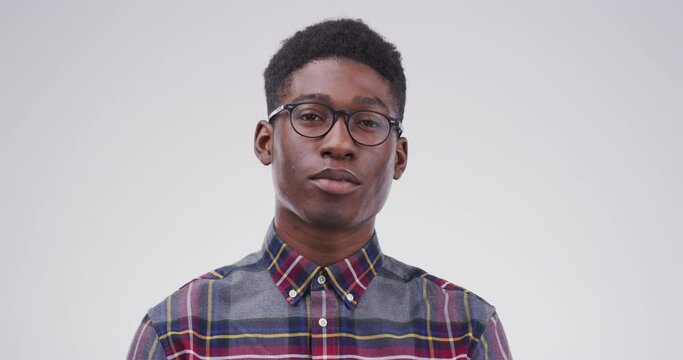 Serious black man, glasses and face of nerd or geek isolated against a studio background. Portrait of smart African person or casual model looking with spectacles, blank stare or eyewear on mockup