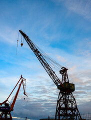 Fototapeta na wymiar Looking up on old wharf cranes.