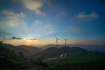 해 뜨는 새벽 풍력 발전기가 있는 산 위 풍경