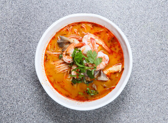 thai rice noodle in tom yum kung soup served in soup isolated on grey background top view of hong...