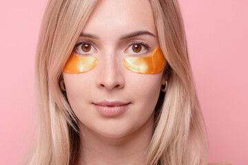 a girl undergoes cosmetic procedures, applies hydrogel patches under her eyes to remove puffiness,...