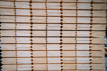 The image features a close-up view of a stack of wooden beams with a unique interlocking pattern.