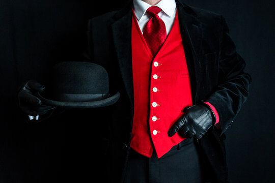 Portrait of Stylish English Gentleman in Dark Suit Red Waistcoat Holding Bowler Hat. Vintage Style and Retro Fashion.