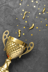 Gold cup with serpentine and stars on dark background, closeup