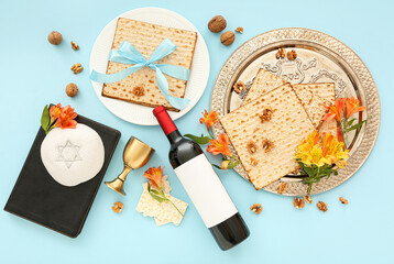 Composition with bottle of wine, flatbread matza, kippah, Torah, walnuts and flowers on color...