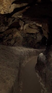 Speleology, cave, dungeon, dark tunnel, underground excavation. Vertical video