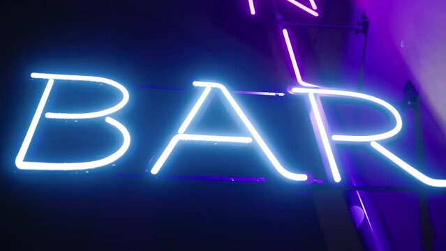 Blue neon BAR sign at night