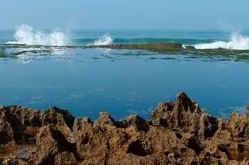 Beautiful view of the Atlantic Ocean with waves crashing and splashing on the headland, forming a...