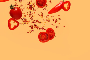 Fototapeta premium Flying vegetables and chili flakes on color background