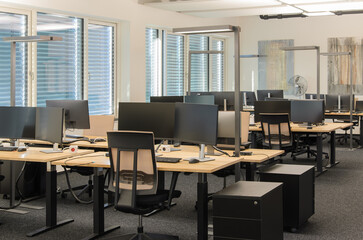 Modern IT office with rows of workstations.