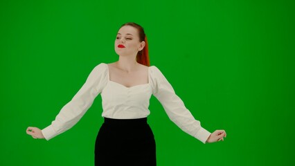 Portrait of attractive office girl on chroma key green screen. Woman in skirt and blouse looking around and starts dancing cutely, smiling face.