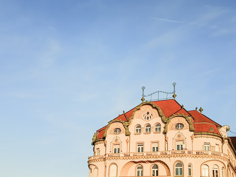 The black eagle palace building facade , art nouveau architecture , on a clear blue sky background in oradea old town, romania. Pastel desaturated colors, minimalist composition with copy space 