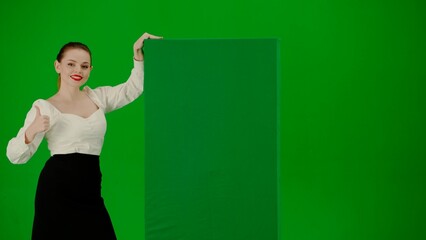 Portrait of attractive office girl on chroma key green screen. Woman in skirt and blouse pointing...