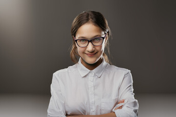 Confident young woman smirks, glasses gleaming smartly