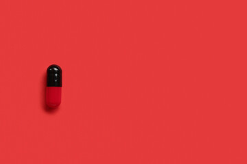Medical capsule on red background