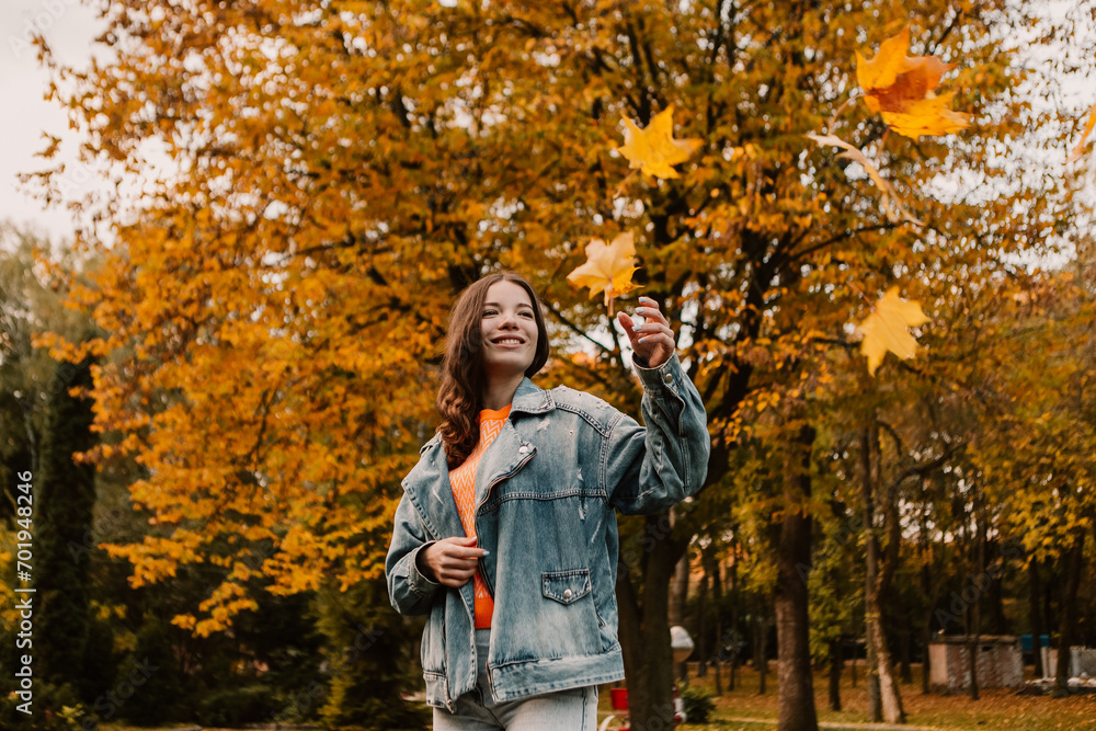 Wall mural caucasian woman walking outdoor, portrait of young european lady in warm sunny autumn park season, f