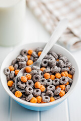 Sweet breakfast cereals in bowl on white table.
