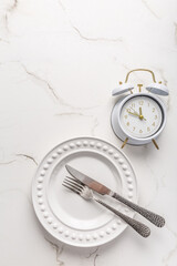 Concept of intermittent fasting, empty plate with clock