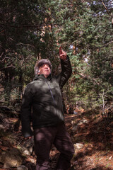 Obraz premium man very warm because of the cold, going down a slope and pointing to the front of the forest