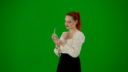 Portrait of attractive office girl on chroma key green screen. Woman in skirt and blouse walking and counting money, happy face expression. Half turn.