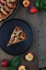 One piece of homemade plum pie on a plate . Rustic style